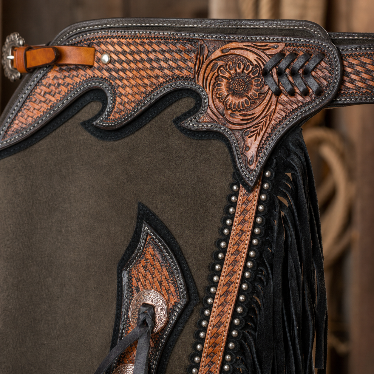Showman Renegade Chinks tooled leather yoke close up with concho ties